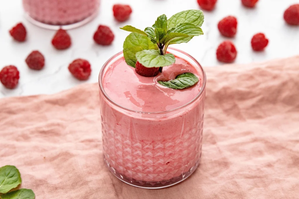 Vaso de milkshake derramado en una mesa de mármol verde en una cocina lujosa
